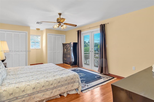 bedroom with ceiling fan, two closets, access to exterior, and light wood-type flooring