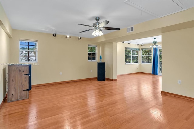 unfurnished room with ceiling fan, a wealth of natural light, and light wood-type flooring