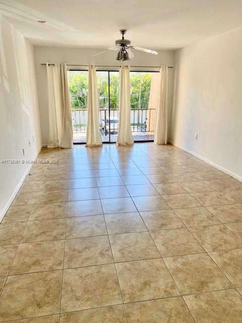 tiled spare room featuring ceiling fan