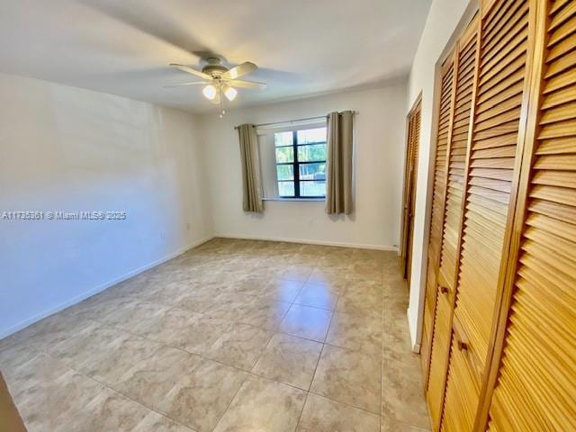 unfurnished bedroom with light tile patterned flooring, ceiling fan, and a closet