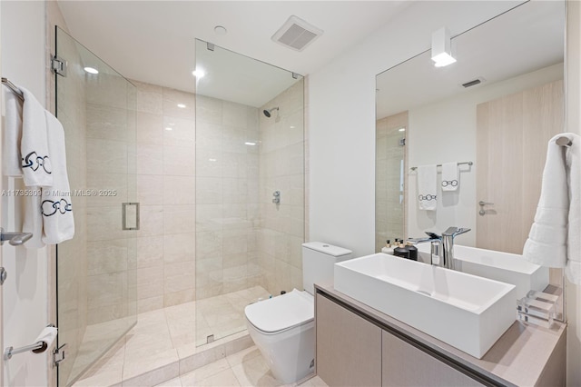 bathroom with vanity, a shower with shower door, and toilet