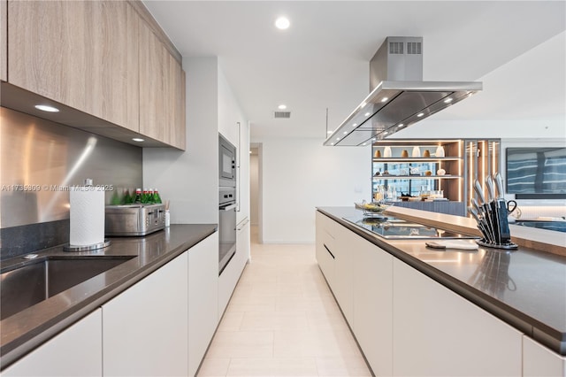 kitchen featuring white cabinetry, light tile patterned floors, light brown cabinets, island exhaust hood, and black appliances