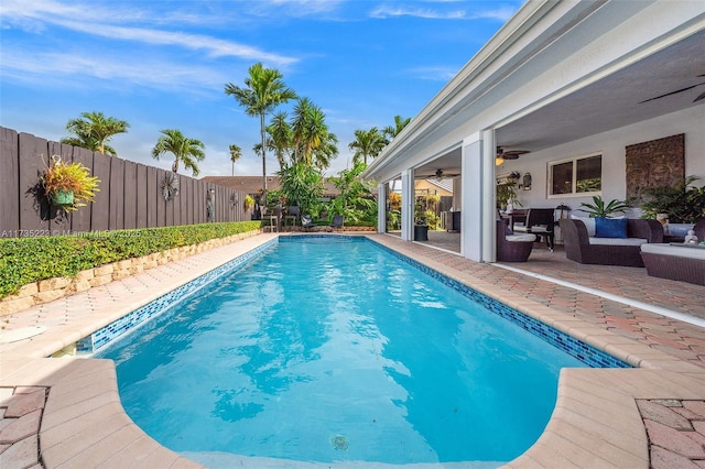 view of pool featuring an outdoor living space, a patio area, and ceiling fan