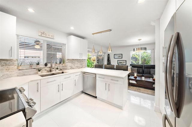 kitchen with white cabinetry, appliances with stainless steel finishes, sink, and kitchen peninsula