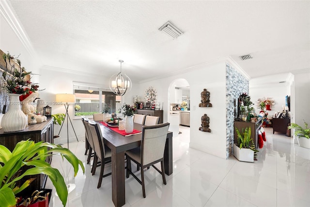 tiled dining space with crown molding, a textured ceiling, and a notable chandelier