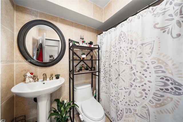 bathroom with tile walls, curtained shower, and toilet