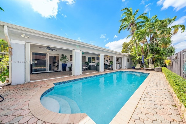 view of swimming pool featuring ceiling fan and a patio area