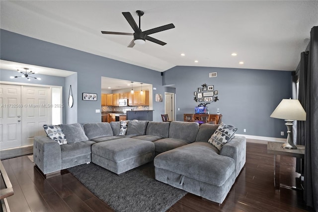 living room featuring lofted ceiling, dark hardwood / wood-style floors, and ceiling fan with notable chandelier