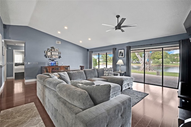 living room with ceiling fan, dark hardwood / wood-style floors, vaulted ceiling, and a textured ceiling