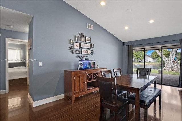 dining room featuring vaulted ceiling and dark wood-type flooring