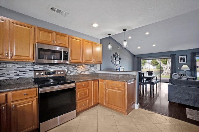 kitchen featuring lofted ceiling, hanging light fixtures, stainless steel appliances, light tile patterned flooring, and kitchen peninsula