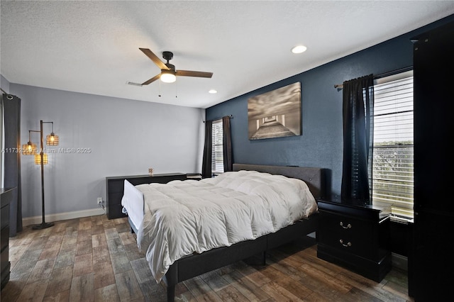 bedroom featuring dark wood-type flooring, ceiling fan, and a textured ceiling