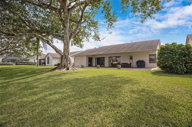 rear view of house featuring a yard and a patio area