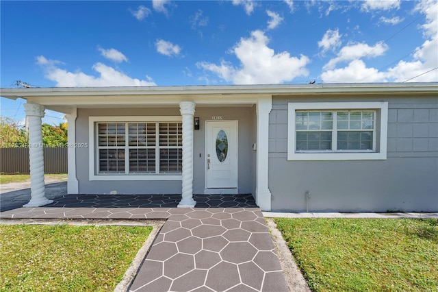 entrance to property with a lawn