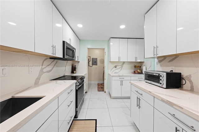 kitchen featuring sink, tasteful backsplash, stainless steel appliances, light stone countertops, and white cabinets