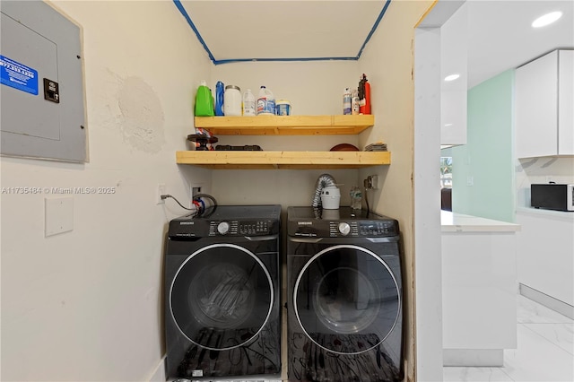 clothes washing area with electric panel and washer and dryer