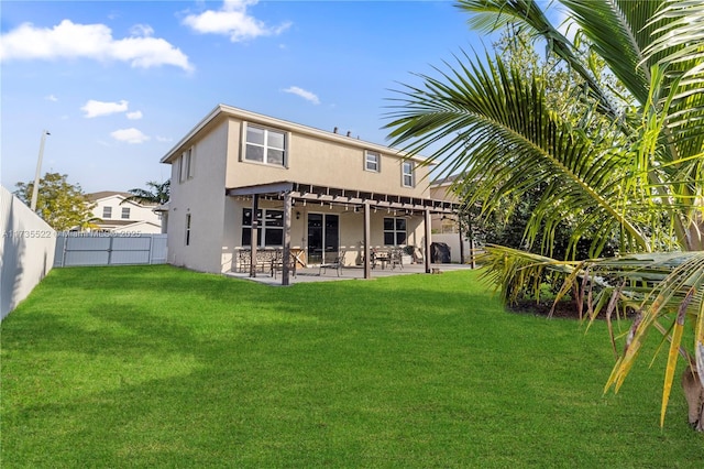 rear view of house with a yard and a patio