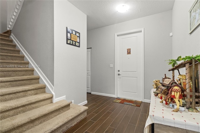 foyer featuring dark hardwood / wood-style flooring and a textured ceiling