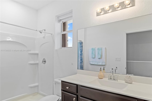 bathroom featuring vanity, curtained shower, and toilet