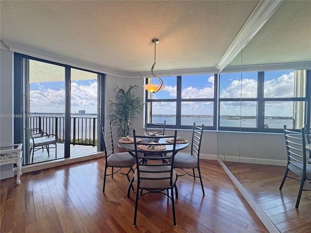 dining room with a textured ceiling, hardwood / wood-style flooring, and crown molding