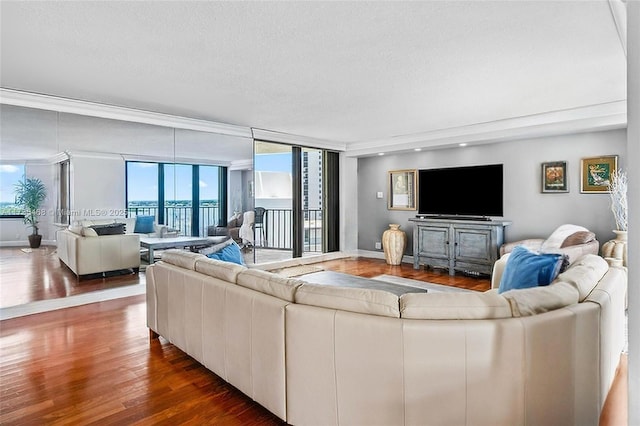 living area with a wealth of natural light, a textured ceiling, baseboards, and wood finished floors