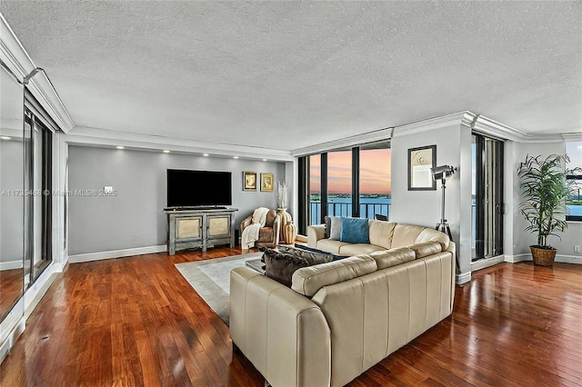 living room featuring a textured ceiling, wood finished floors, crown molding, and baseboards