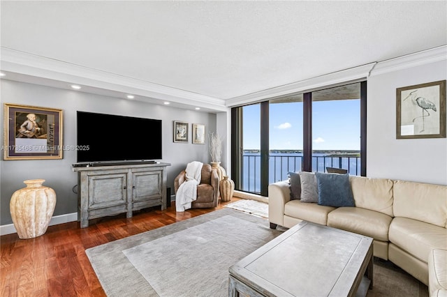 living room with dark wood-type flooring, crown molding, recessed lighting, and baseboards