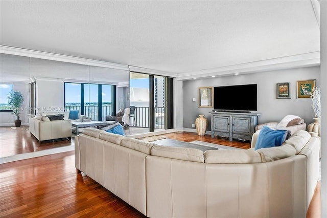 living room with wood finished floors, healthy amount of natural light, baseboards, and a textured ceiling