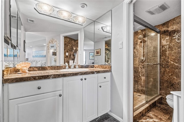 full bathroom featuring toilet, a shower stall, visible vents, and vanity