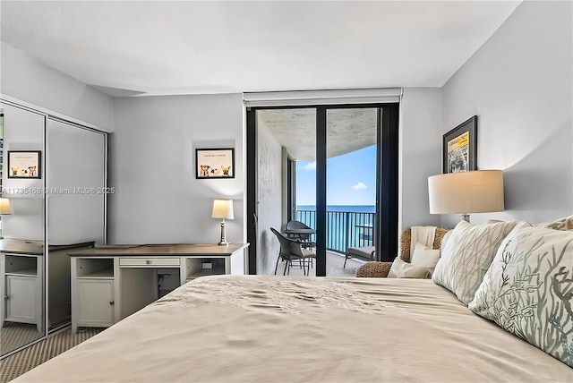bedroom featuring floor to ceiling windows, access to exterior, and a water view