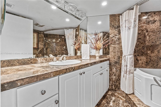 full bathroom featuring visible vents, marble finish floor, vanity, and tile walls