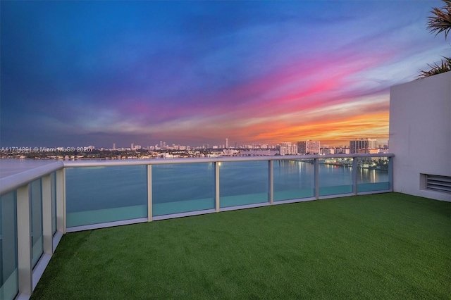 view of yard featuring a water view, a balcony, and a city view