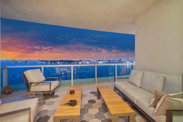 balcony at dusk featuring a city view and an outdoor hangout area