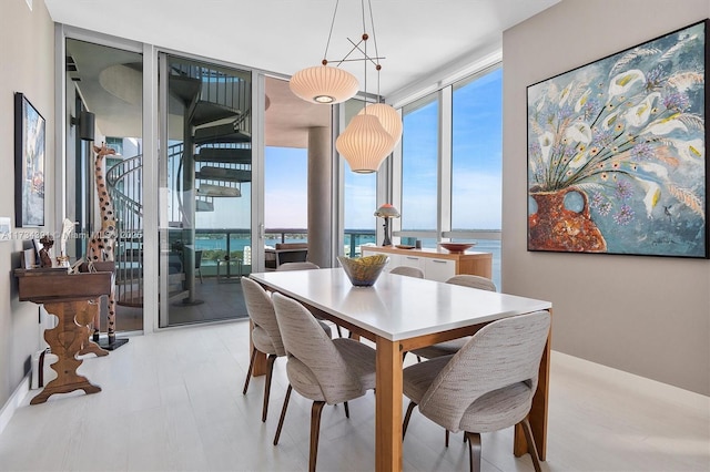 dining space with floor to ceiling windows and a water view