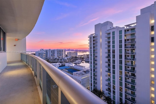 balcony at dusk featuring a city view