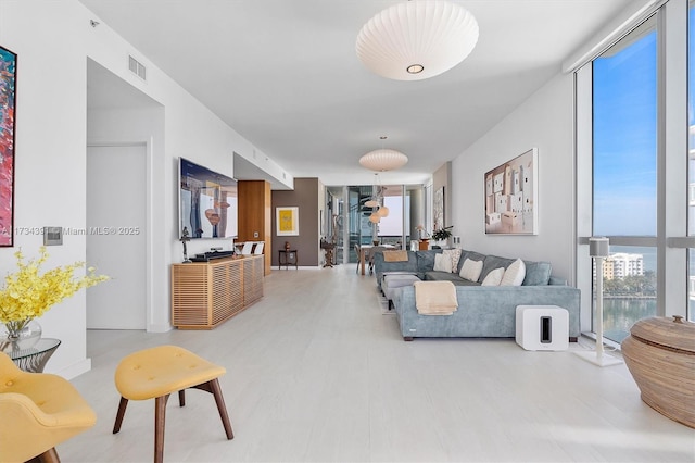 living room with visible vents and a wall of windows