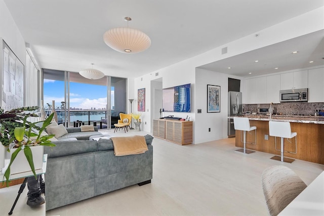 living area with visible vents, recessed lighting, and a wall of windows