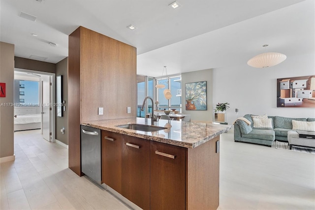 kitchen with light stone counters, open floor plan, modern cabinets, and a sink