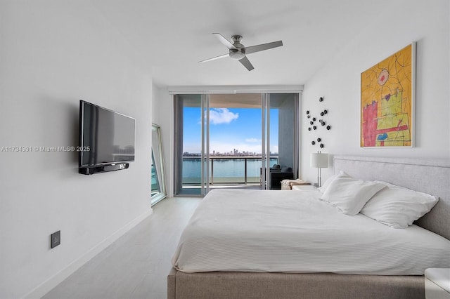 bedroom with a ceiling fan, wood finished floors, baseboards, expansive windows, and access to outside