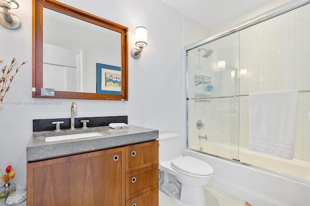 full bath featuring vanity, toilet, and shower / bath combination with glass door