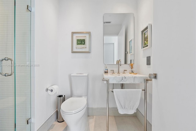 bathroom with a shower stall, toilet, visible vents, and a sink