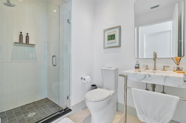 bathroom featuring toilet, baseboards, visible vents, and a stall shower