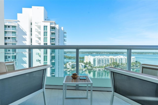 balcony with a water view and a view of city