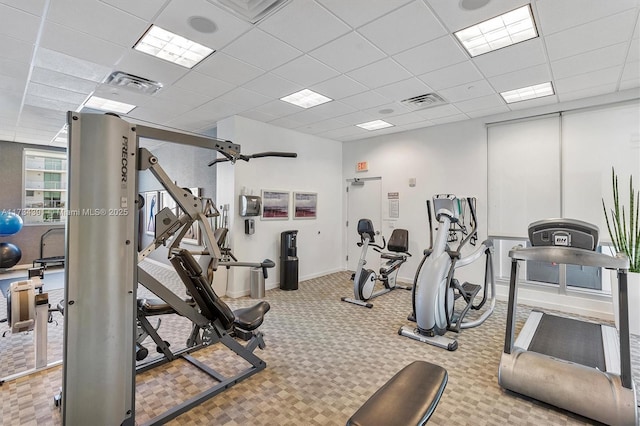 workout area with visible vents, a paneled ceiling, baseboards, and carpet flooring