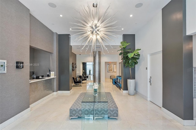 hallway featuring recessed lighting, baseboards, and a towering ceiling