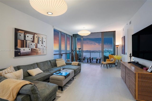 living area featuring a wall of windows, wood finished floors, and visible vents