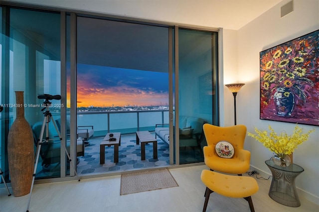 living area featuring visible vents and expansive windows