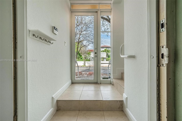 doorway to outside with light tile patterned floors