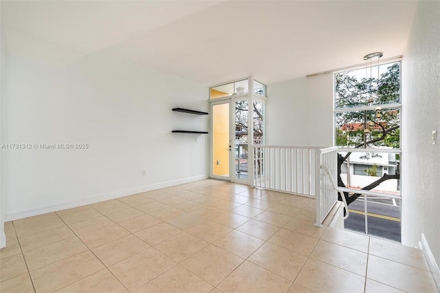 unfurnished room featuring floor to ceiling windows and light tile patterned floors