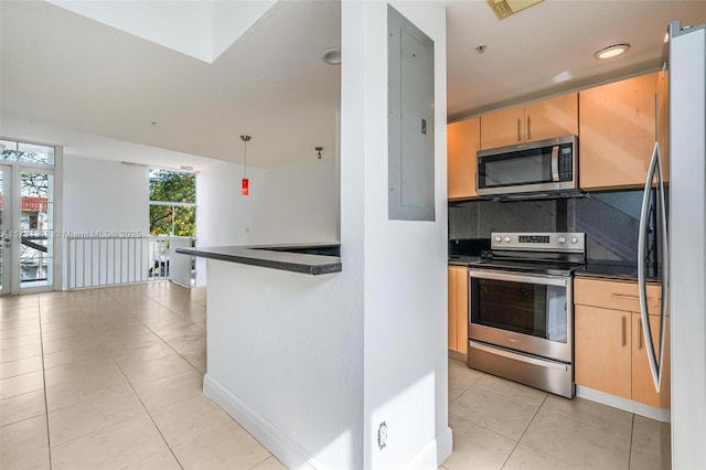 kitchen featuring hanging light fixtures, appliances with stainless steel finishes, light brown cabinets, and backsplash